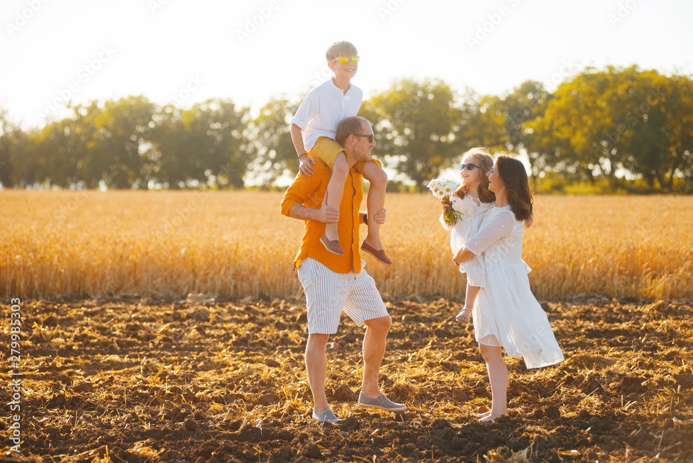 Fototapeta premium Photo concept, handsome family having fun in wheat field on sunnset