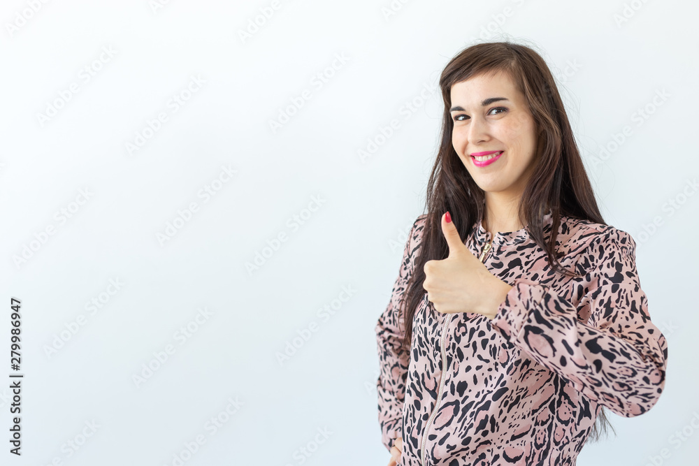 Smiling pretty young woman showing thumbs up isolated on the white background with copy space Smiling pretty young woman showing thumbs up isolated on the white background with copy space