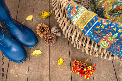 Rubber boots and wicker basket closeup. Autumn concept. Hike for mushrooms in the forest.