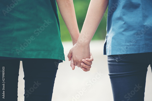 two asian woman holding hands
