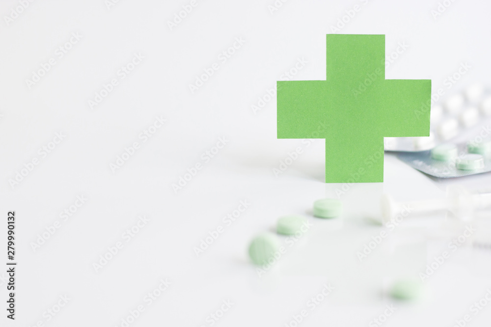 Green medical cross symbol and syringe with pill on white background Green medical cross symbol and syringe with pill on white background