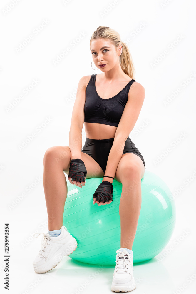 Fototapeta premium Woman making exercise with pilates ball, against white background