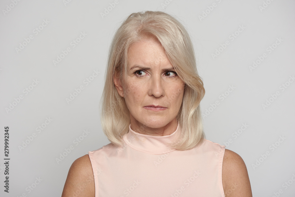 Angry beautiful senior lady looking away isolated on grey Angry beautiful senior lady looking away isolated on grey