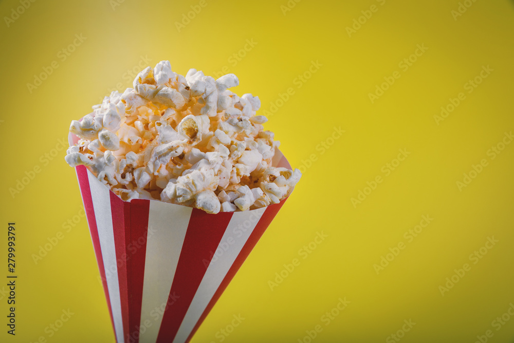 striped pop corn bag on yellow background with copy space
