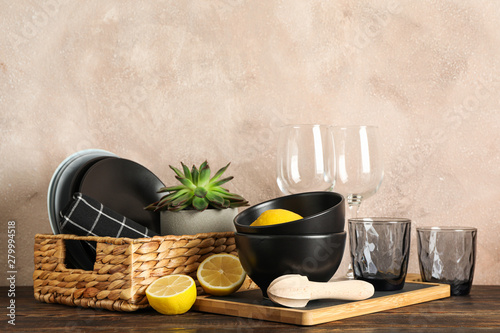 Set of dinnerware with succulent plant and lemons on wooden table, space for text