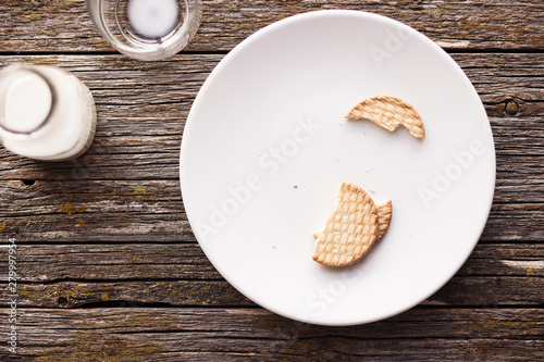 Aerial view of some pieces of biscuit and some milk on rustic table