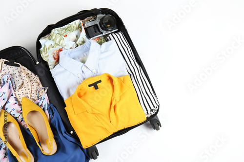Canvas-taulu Open suitcase fully packed with folded women's clothing and accessories on the floor