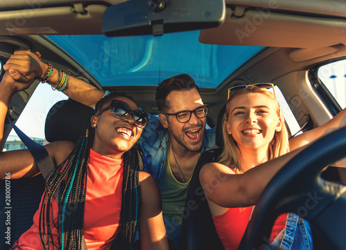 Three best friends enjoying traveling at vacation in the car. photo