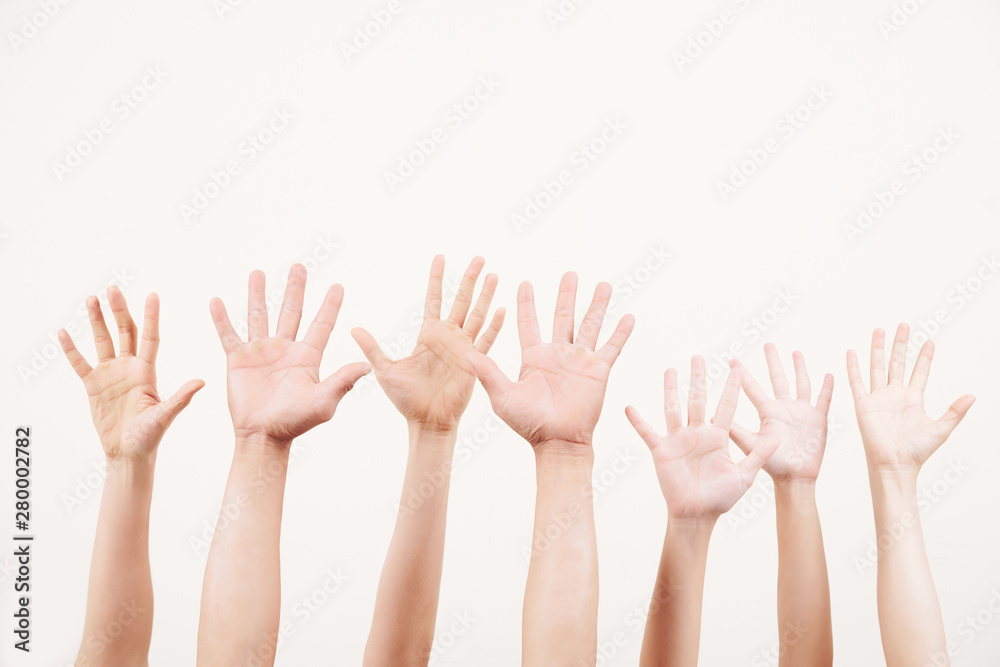 Close-up of crowd of young people stretching their arms up and voting together over white background