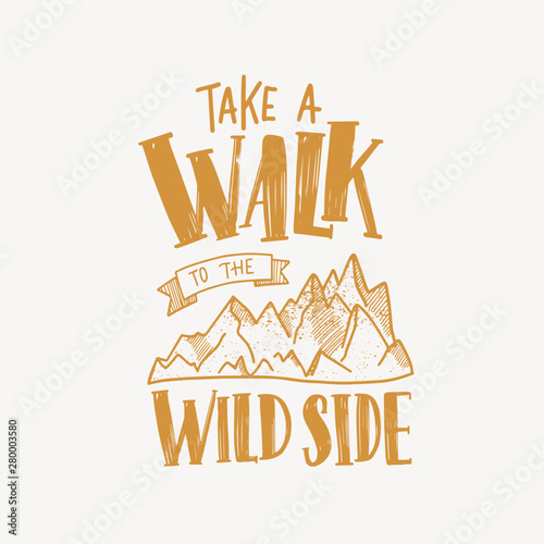 Take A Walk To The Wild Side motivational slogan or text handwritten with calligraphic font and decorated by mountains