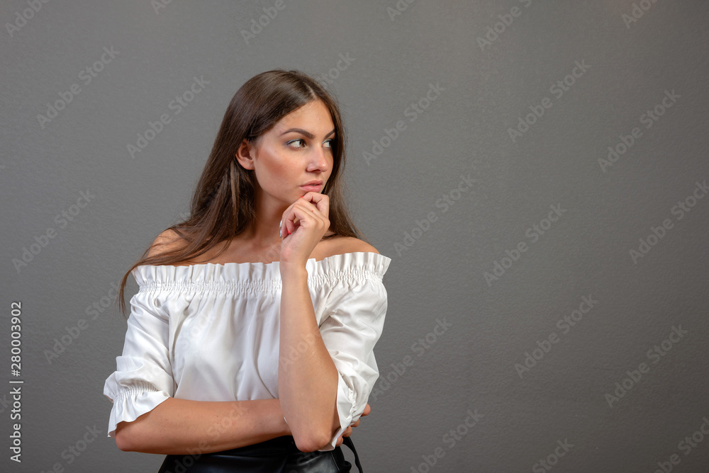 Portrait of a thoughtful woman looking away at copyspace over gray background - image Portrait of a thoughtful woman looking away at copyspace over gray background - image