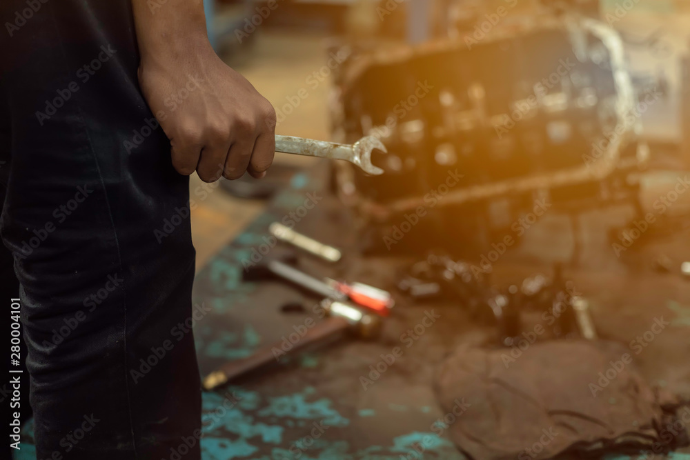 Obraz premium Close up, Service car is People are repair a car Use hand a wrench and a screwdriver to work.Engine repair technicians are hold the wrench in order to repair the car.Image is tone.