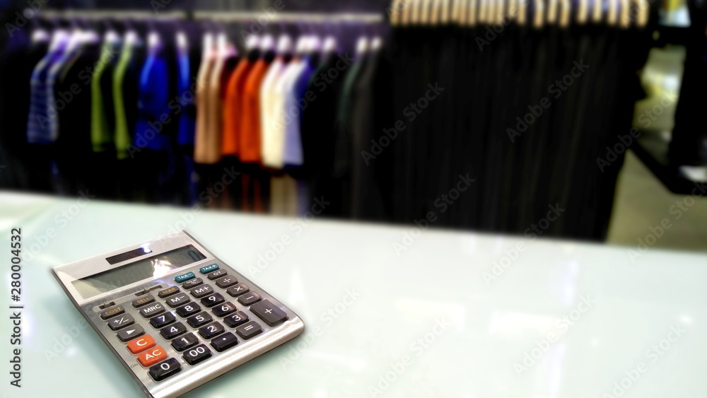 close up calculator on white counter for calculate price of fashion cloth for wear to working, focus at calculator and blur around it. close up calculator on white counter for calculate price of fashion cloth for wear to working, focus at calculator and blur around it.