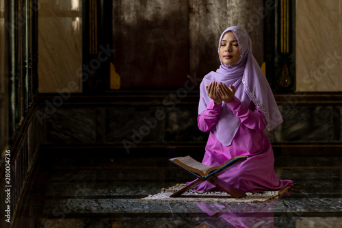 Muslim women wearing purple shirts Doing prayer According to the principles of Islam..