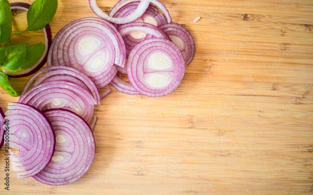 Red onion slices isolated on wooden chopping board Red onion slices isolated on wooden chopping board