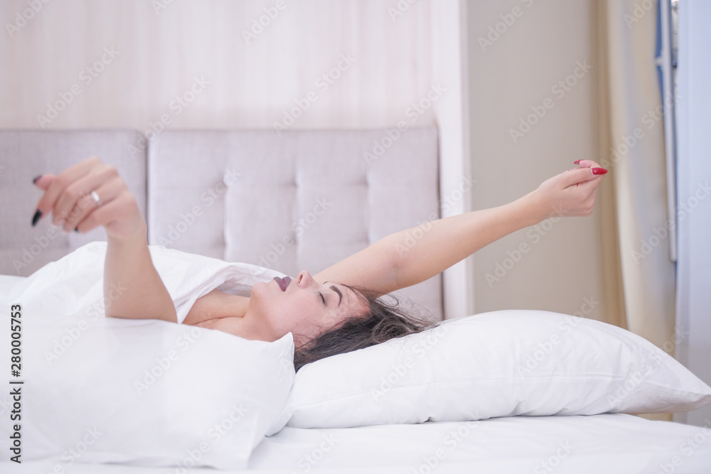 charming young brunette girl resting in her white bed charming young brunette girl resting in her white bed