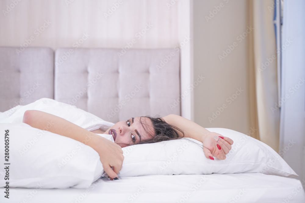 charming young brunette girl resting in her white bed charming young brunette girl resting in her white bed