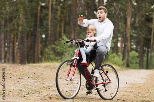 Worried father and daughter on bicycle