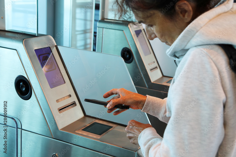 Woman is check in with smart phone in airport gate before flight Woman is check in with smart phone in airport gate before flight