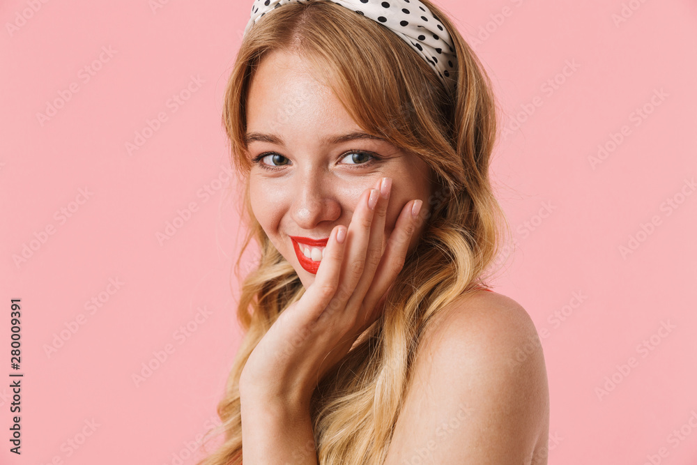 Image closeup of blonde young woman with long curly hair smiling and looking at camera Image closeup of blonde young woman with long curly hair smiling and looking at camera