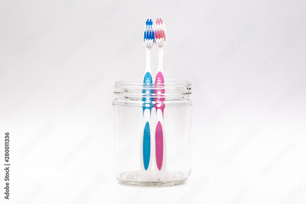 Couple toothbrush in a glass jar isolated in white background Couple toothbrush in a glass jar isolated in white background