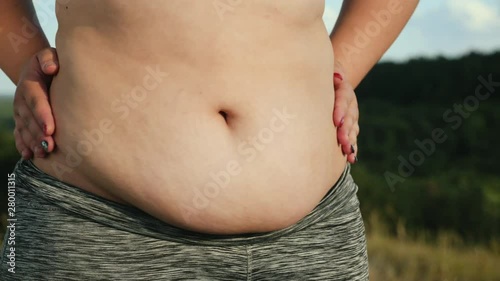 The overweight woman shakes her fat belly