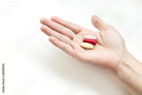 Vitamins supplements on woman hand,