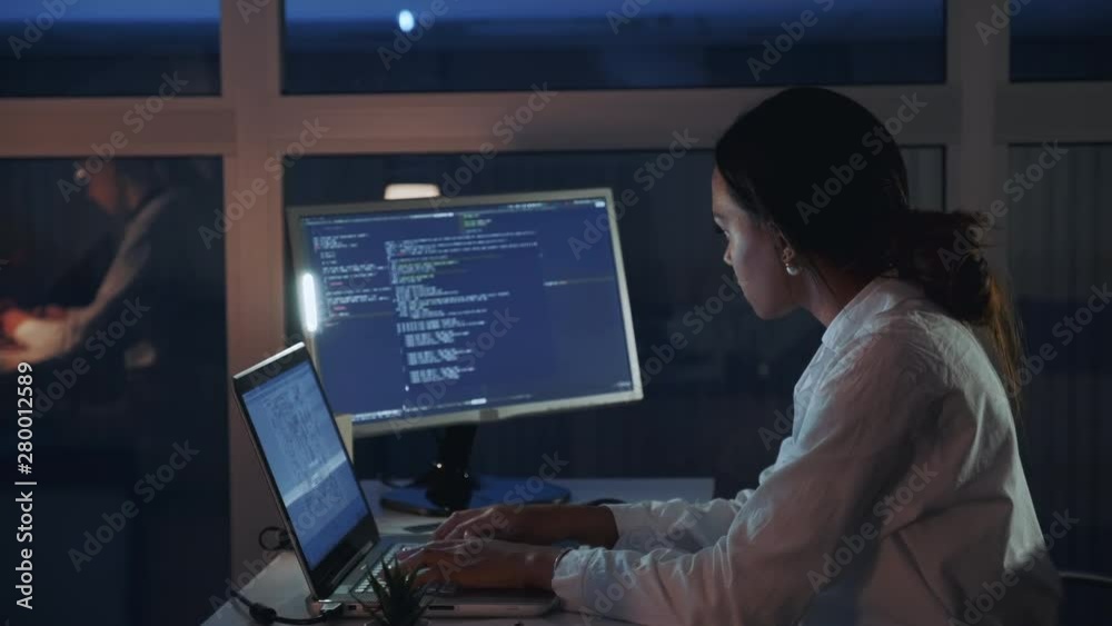 Side view of african american female engineer working on computer in electronics laboratory. Doing Development of Software and Hardware. She wearing a lab coat