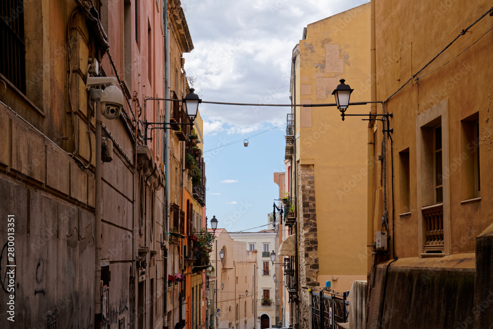 Typical row houses in Cagliari in Italy (Sardinia) with zipline and hanging basket between the windows.