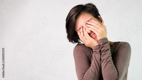 Studio portrait of an attractive middle aged asian woman hands covering eyes, gesturing of don't want to see. Social network, Dangers, Information age, Computer vision syndrome, See no evil concept.