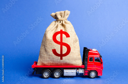 Red truck carries a big bag of money. Attracting investment in development and modernization of production and business projects. Revenue profit. super profit. corruption schemes. Financial groups photo