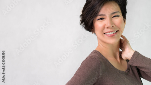 Studio portrait of an attractive asian middle aged woman model in her 40s smiling feeling cheerful, Satisfied and Confident. Short hairstyle, Wringkle Aging, Middle aged beauty and healthy concept. photo