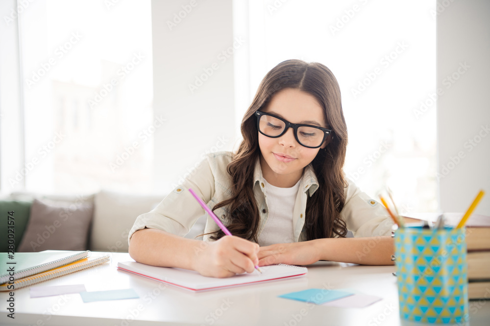 Portrait of her she nice attractive lovely charming cute peaceful confident intellectual wavy-haired pre-teen girl wearing eyewear eyeglasses writing copybook in light white interior room indoors Portrait of her she nice attractive lovely charming cute peaceful confident intellectual wavy-haired pre-teen girl wearing eyewear eyeglasses writing copybook in light white interior room indoors