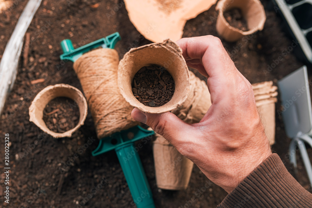 Valokuva Biodegradable cardboard planting pot in hand of male gardener