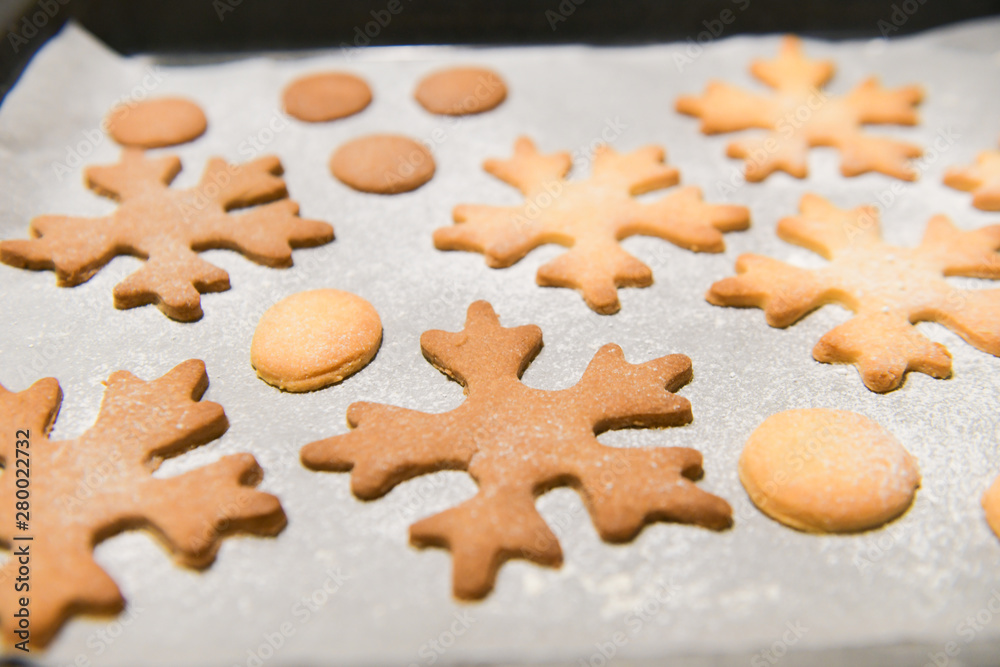 Snowflake cookies, baking on the baking sheet. Christmas gingerbread homemade. Merry Christmas card.