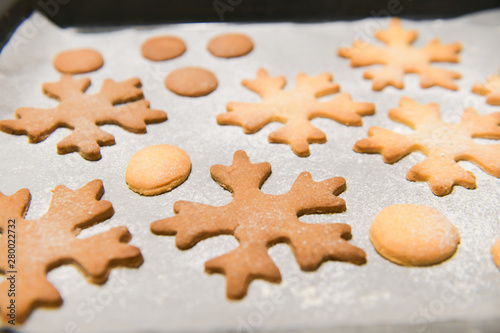 Snowflake cookies, baking on the baking sheet. Christmas gingerbread homemade. Merry Christmas card.