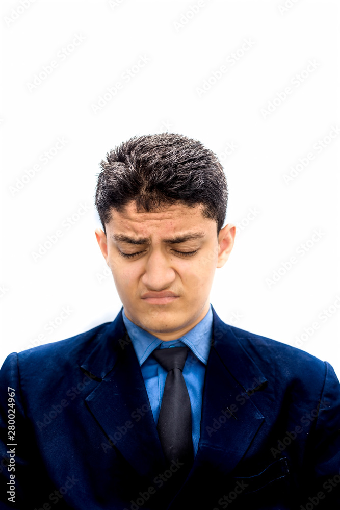 Portrait shot exhausted of apprentice young businessman isolated on white wearing a blue colored shirt and black necktie and expressing tired laziness on his face. Portrait shot exhausted of apprentice young businessman isolated on white wearing a blue colored shirt and black necktie and expressing tired laziness on his face.