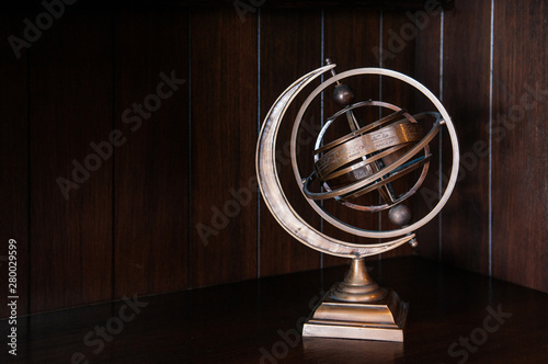 Vintage retro classic zodiac globe armillary sphere model on dark wood background photo