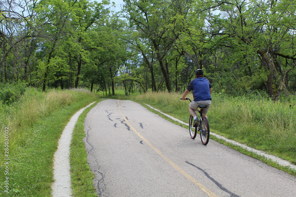 Man riding a bike on the North Branch Trail at Miami Woods in Morton Grove, Illinois