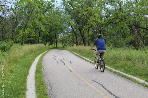 Man riding a bike on the North Branch Trail at Miami Woods in Morton Grove, Illinois