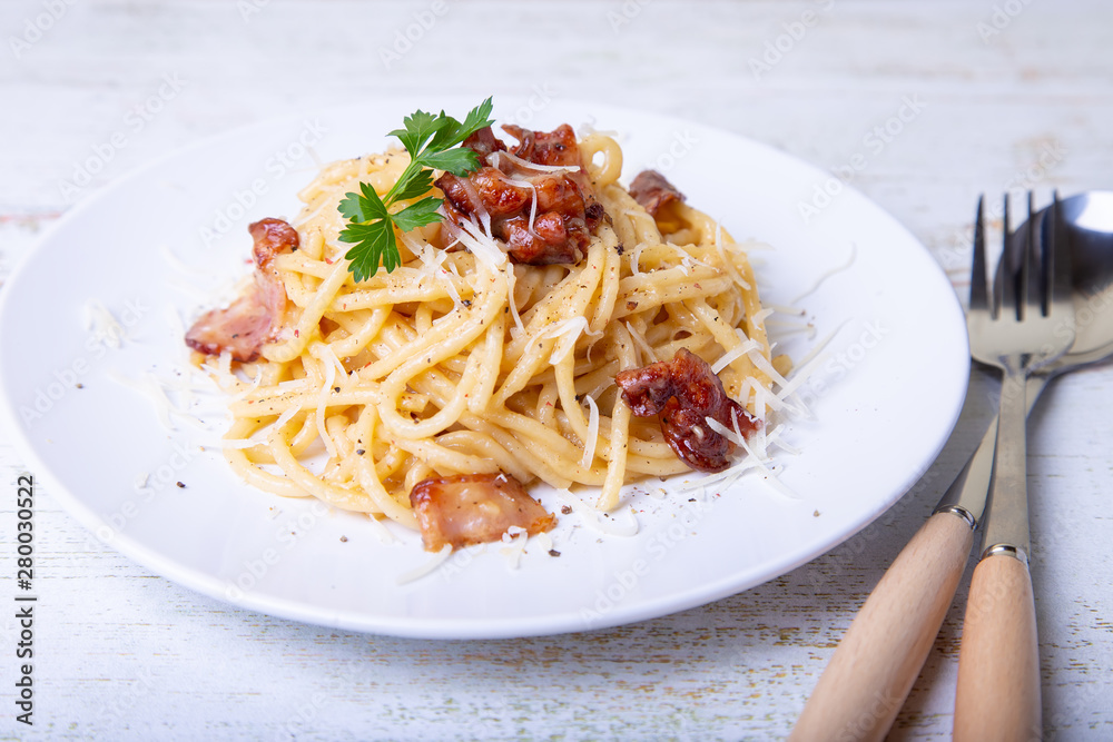 Pasta carbonara with bacon, cheese Parmesan and parsley. Traditional Italian dish. Close-up, selective focus. Pasta carbonara with bacon, cheese Parmesan and parsley. Traditional Italian dish. Close-up, selective focus.