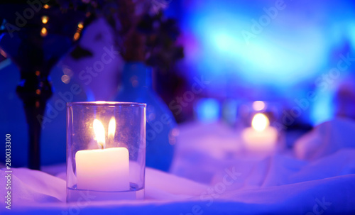 Small candlelight that have yellow spots on purple light and white background in the room of party of celebration