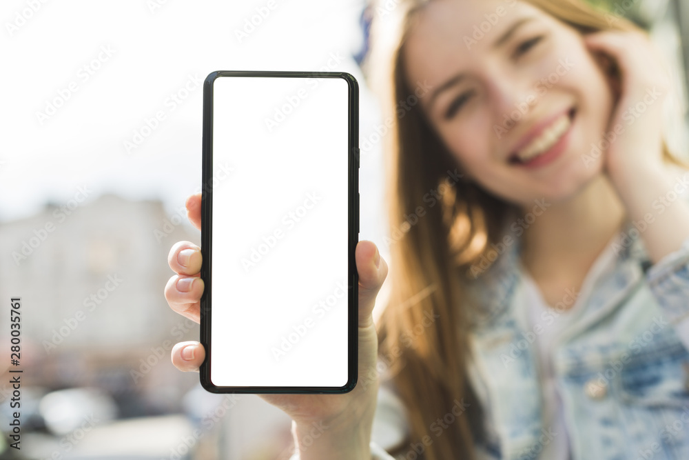 Smiling woman showing blank screen smartphone