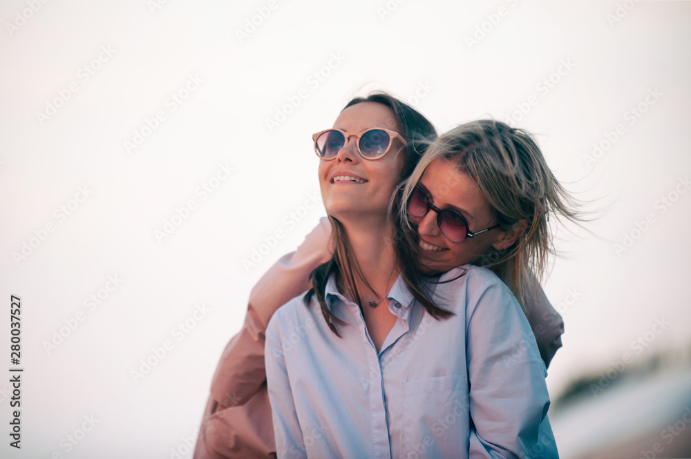 Two young attractive women resting together at sunset Two young attractive women resting together at sunset