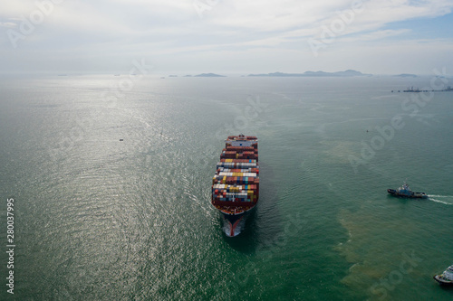 Aerial view and top view. Container ship in pier with crane bridge carries out export and import business in the open sea. Logistics and transportation