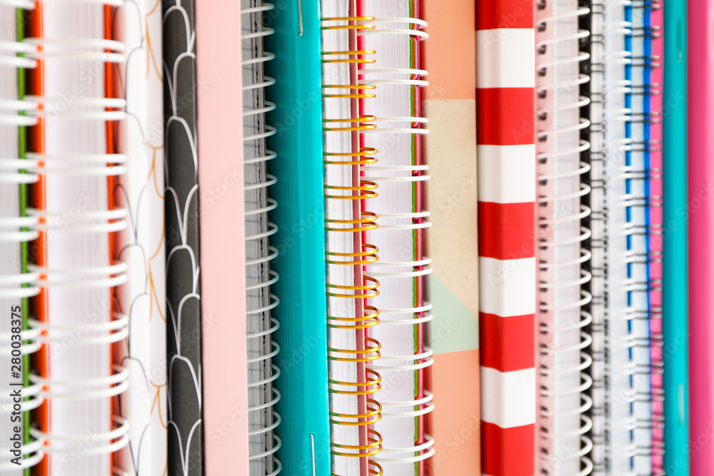 Stack of colorful books and copybooks as background, closeup