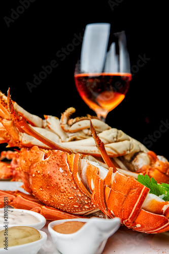 Fabulous lobster dish on wooden table with wine and all the finesse of a luxury restaurant. photo