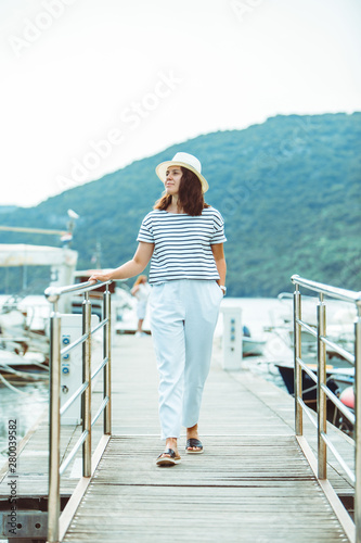 woman in white fashion luxury view walking by dock boats on background