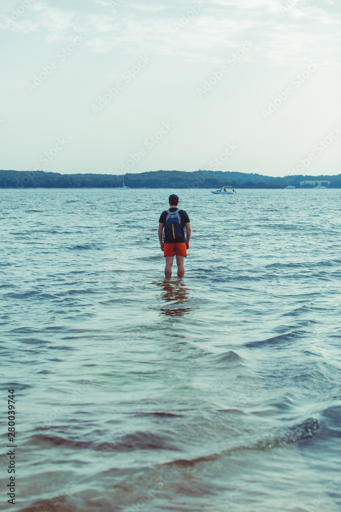 man standing in the sea water at beach