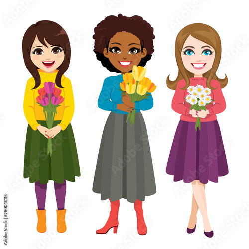 Three beautiful young women holding flower bouquet in casual fashion clothing